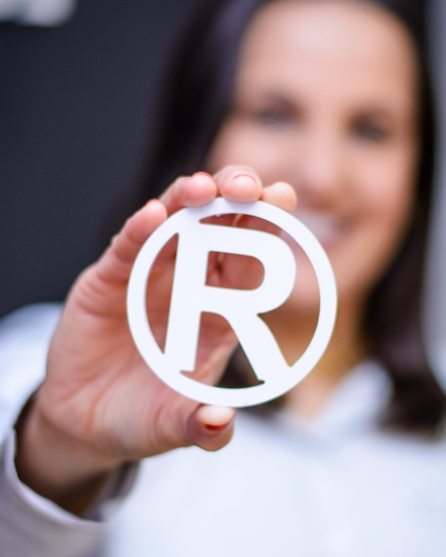 Profissional da Objetiva segurando o símbolo de marca registrada